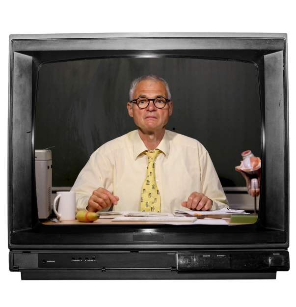 Das Bild zeigt einen alten Fernseher, in dem ein Lehrer zu sehen ist, der vor einer Tafel an einem Tisch sitzt. Der Lehrer trägt ein Hemd, eine Krawatte und eine Brille und hat einen leicht ängstlichen und überforderten Gesichtsausdruck. Auf dem Tisch ist ein Overhead-Projektor, eine Kaffeetasse, eine Banane, die mit einem Kondom überzogen ist, ein aufgeschlagenes Buch, ein Stapel Papier und ein anatomisches Penismodell zu sehen.